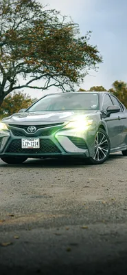 Белая toyota camry стоит по середине дороги - обои на телефон