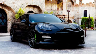 Чёрный porsche panamera на фоне старинного города - обои на рабочий стол